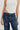 Blue jeans with star-shaped embellishments worn by a person on a white background