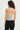 Woman wearing a polka dot top and black pants on a white background