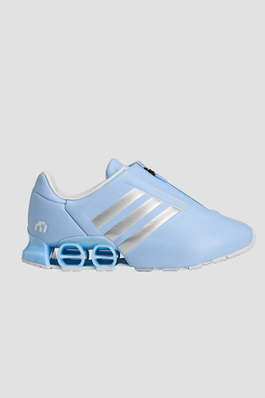 Light blue adidas athletic shoes with silver stripe white soles and a zipper tongue on a light gray background