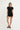 black shortsleeve knit romper with mother of pearl buttons at bust and waist