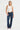 Woman wearing white cotton tank top with scoop hem and dome studs on neckline