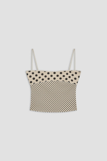 Polka dot top with thin straps on a light gray background